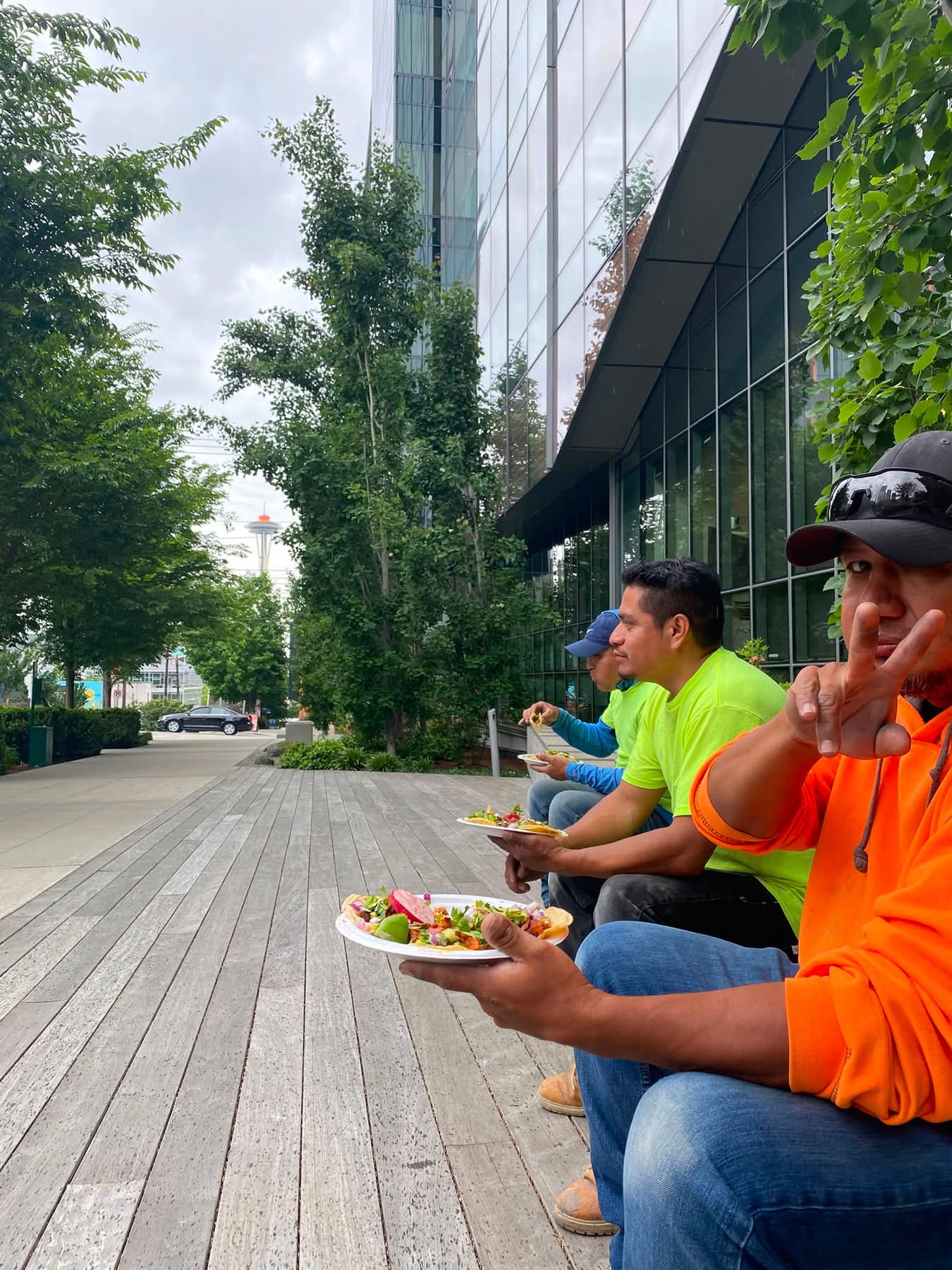 Customers enjoying Barriga Llena tacos on the South Lake Union boardwalk with the Space Needle in view