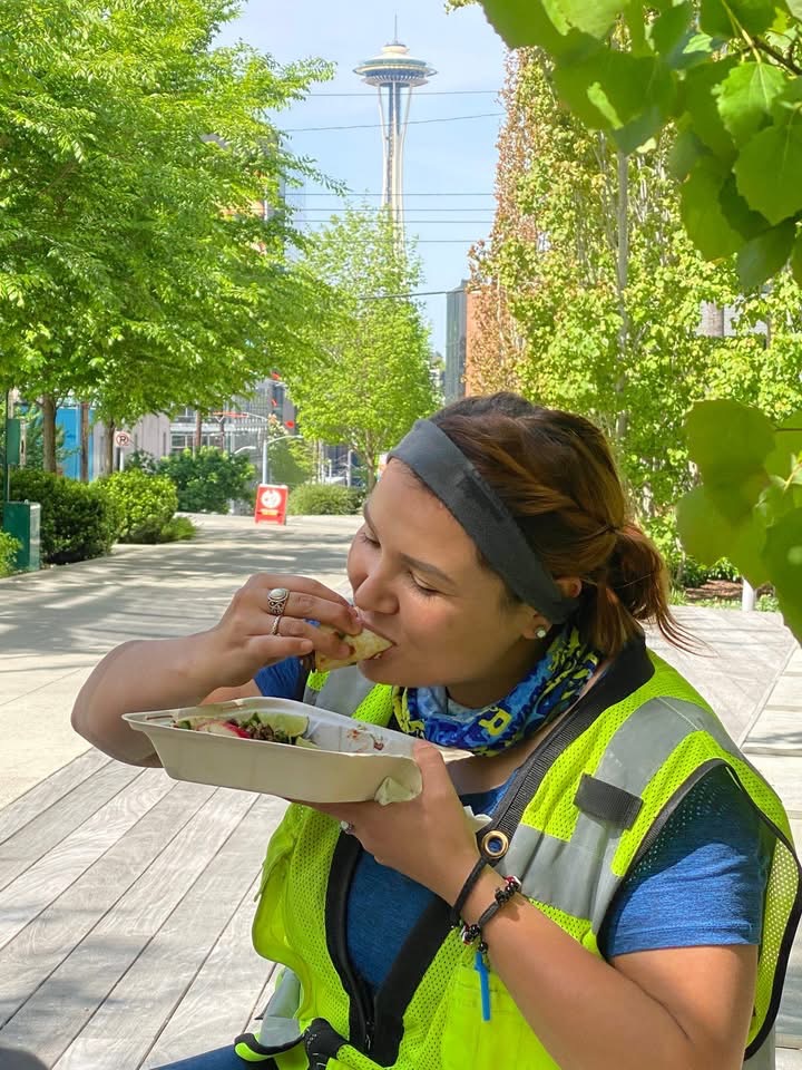 A customer enjoying Barriga Llena tacos near the Space Needle